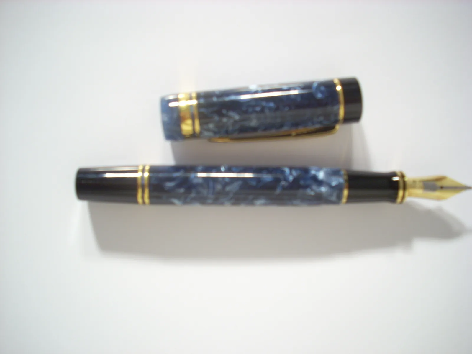 Blue marbled fountain pen shown uncapped with the nib visible