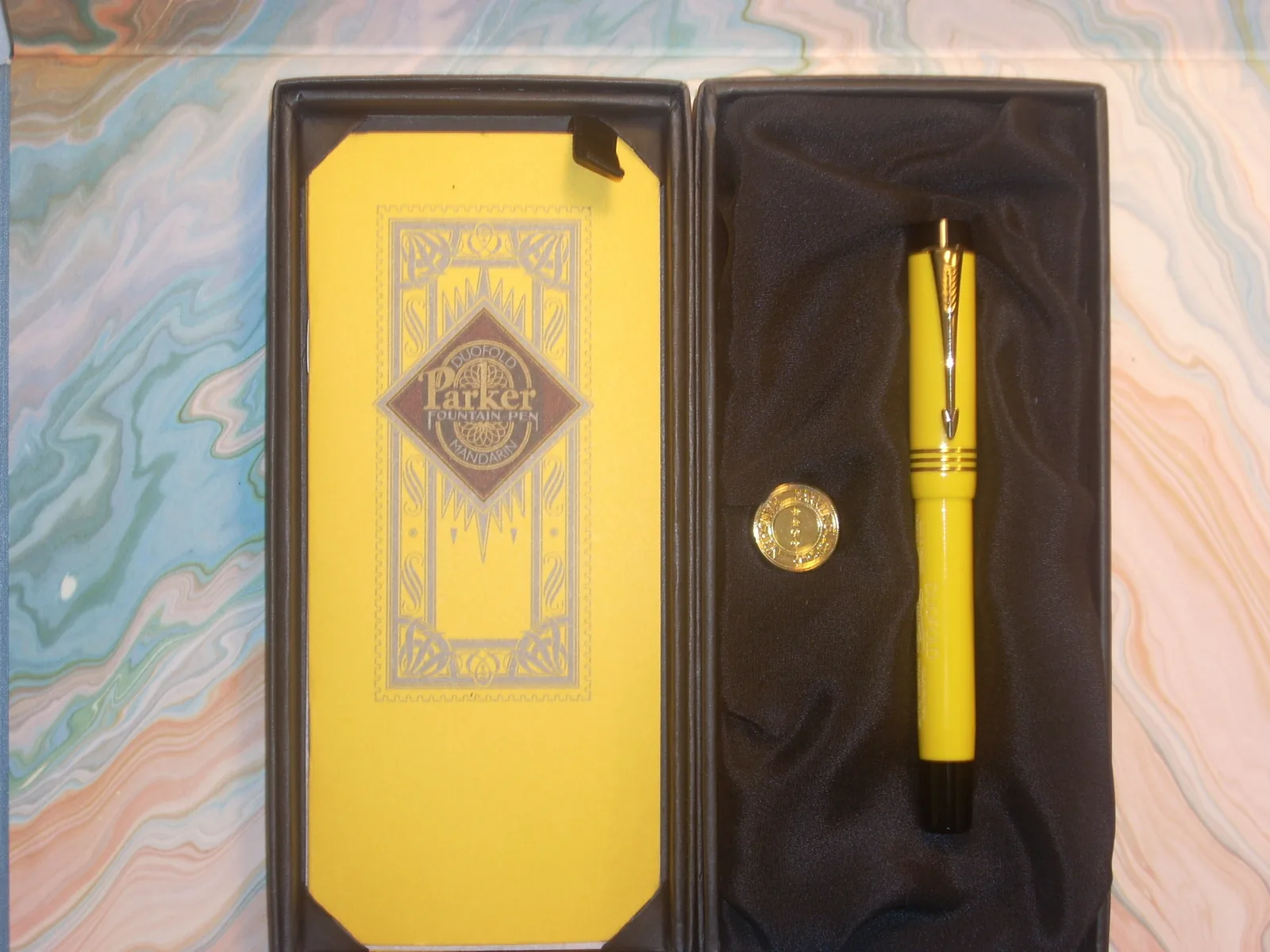Yellow Parker Duofold Mandarin fountain pen displayed with its presentation box and booklet