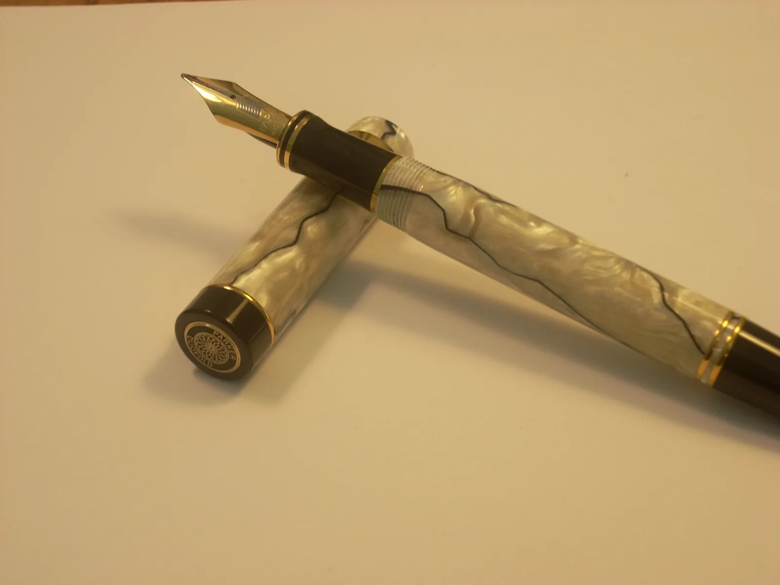 Open pearl-pattern Parker Duofold fountain pen showing its nib and cap medallion