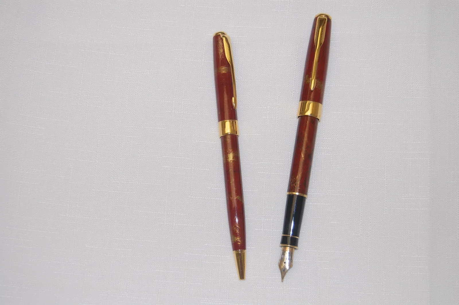 Red marbled fountain pen and matching writing instrument with gold-tone trim